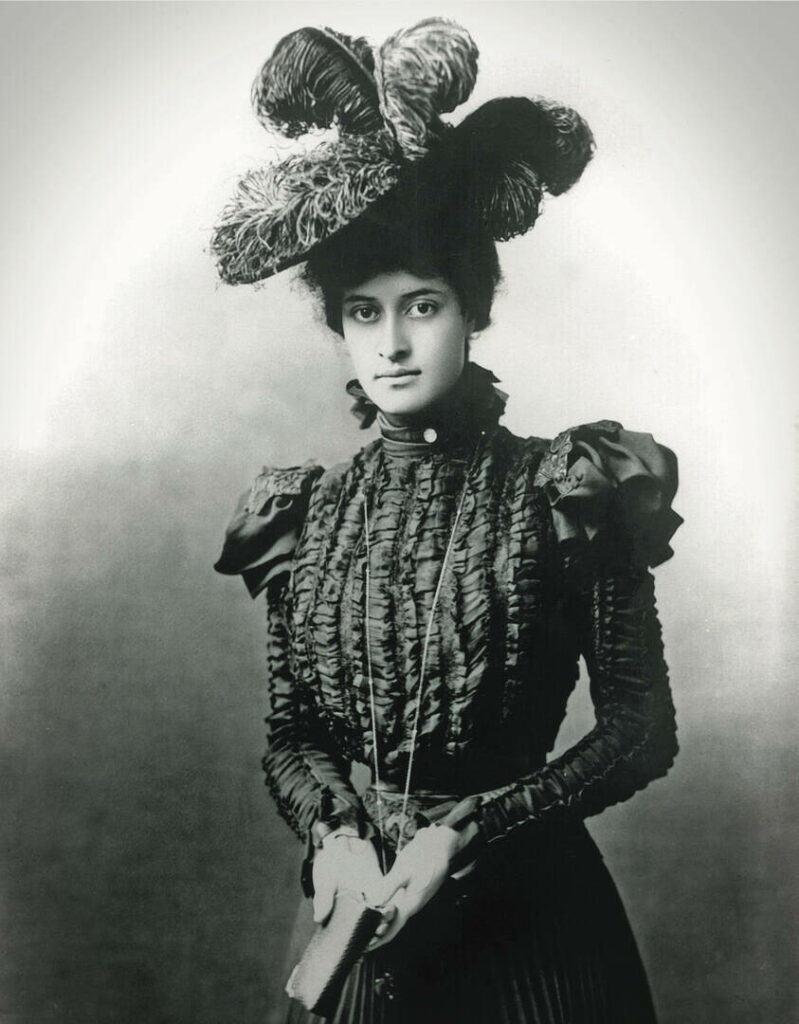 Princess Ka‘iulani in dark silk gown and hat with feathers in Hawaiian Women's Fashions
